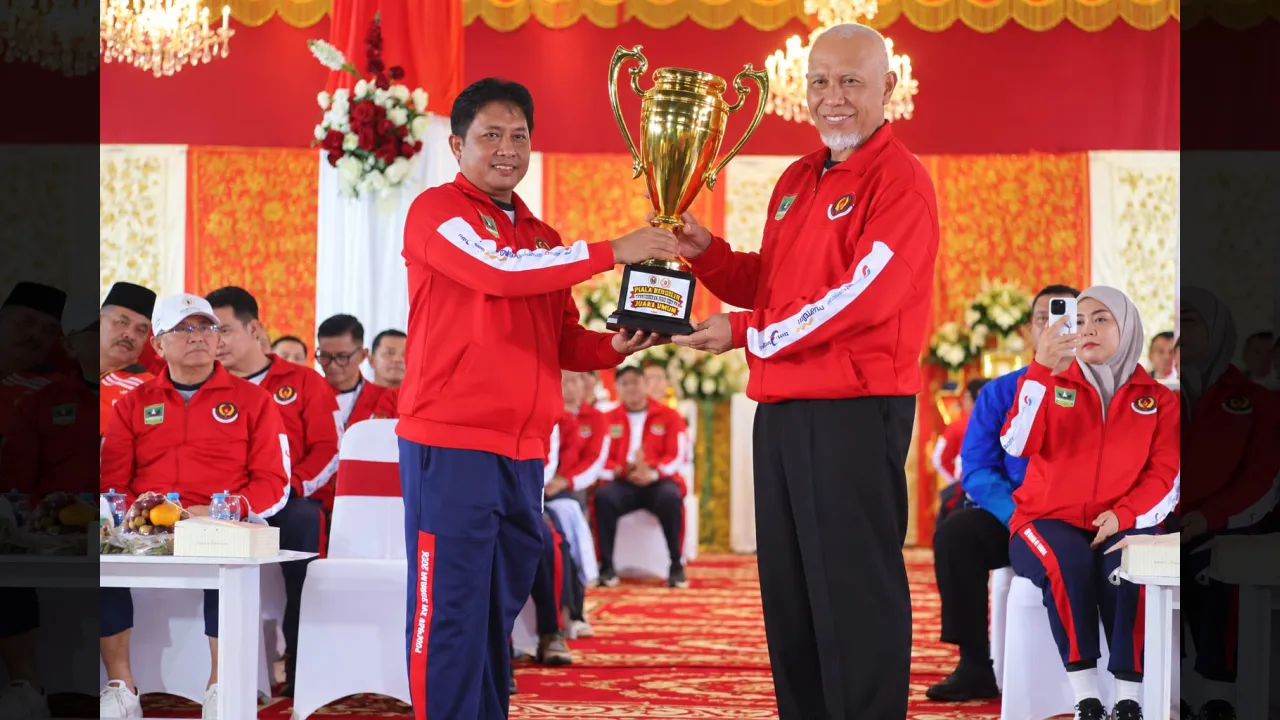 Penyerahan Piala Bergilir Porprov dari Ketua KONI Sumbar Hamdanus kepada Gubernur Sumbar Mahyeldi (KONI Sumbar)